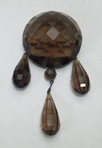 Faceted brown crystal with three teardrop pendants.