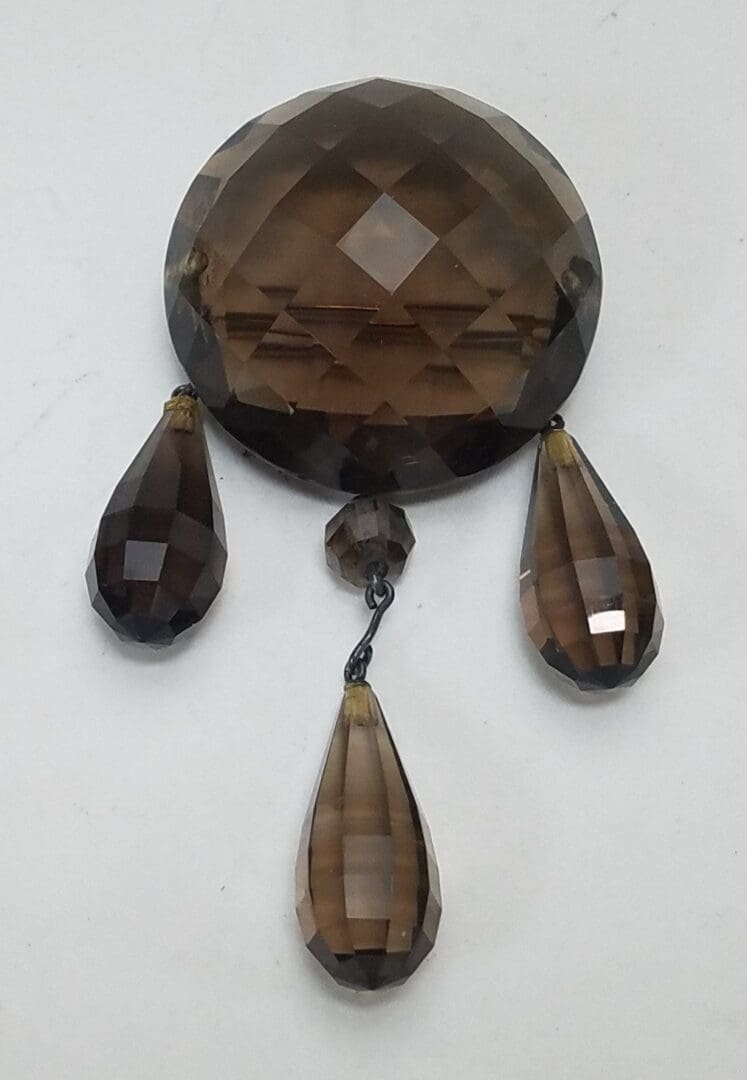 Faceted brown crystal with three teardrop pendants.