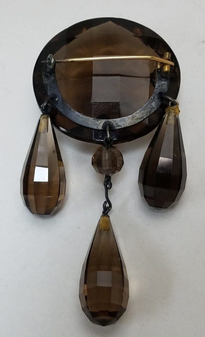 Vintage brooch with faceted brown glass pendants.