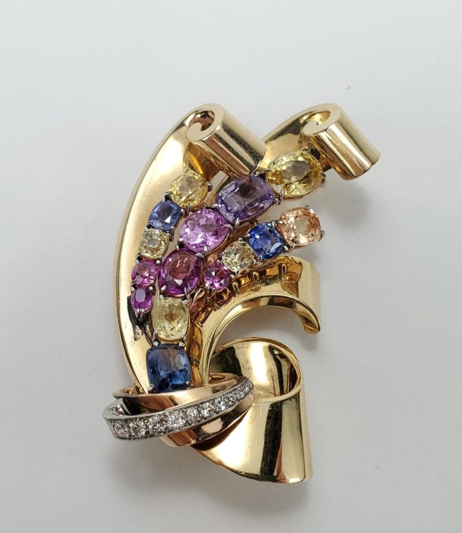 Gold brooch with colorful gemstones and diamonds.