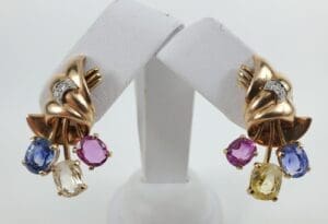 Gold earrings with colorful gemstone dangles.