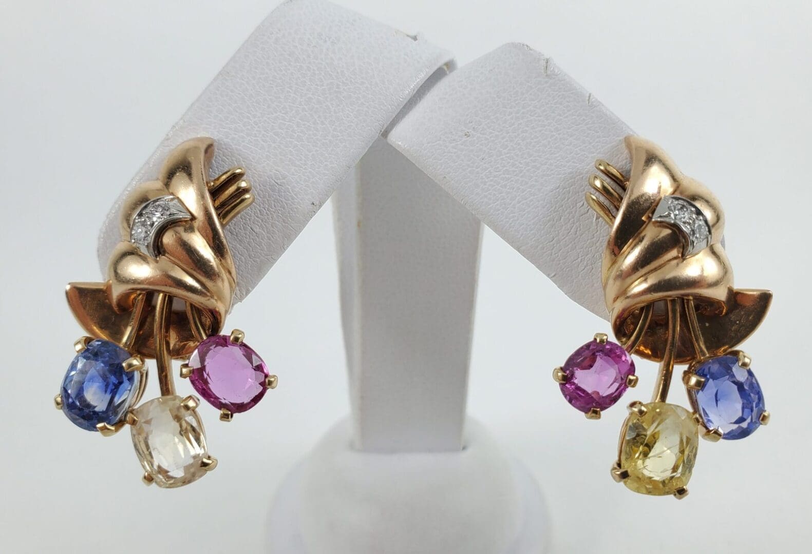 Gold earrings with colorful gemstone dangles.