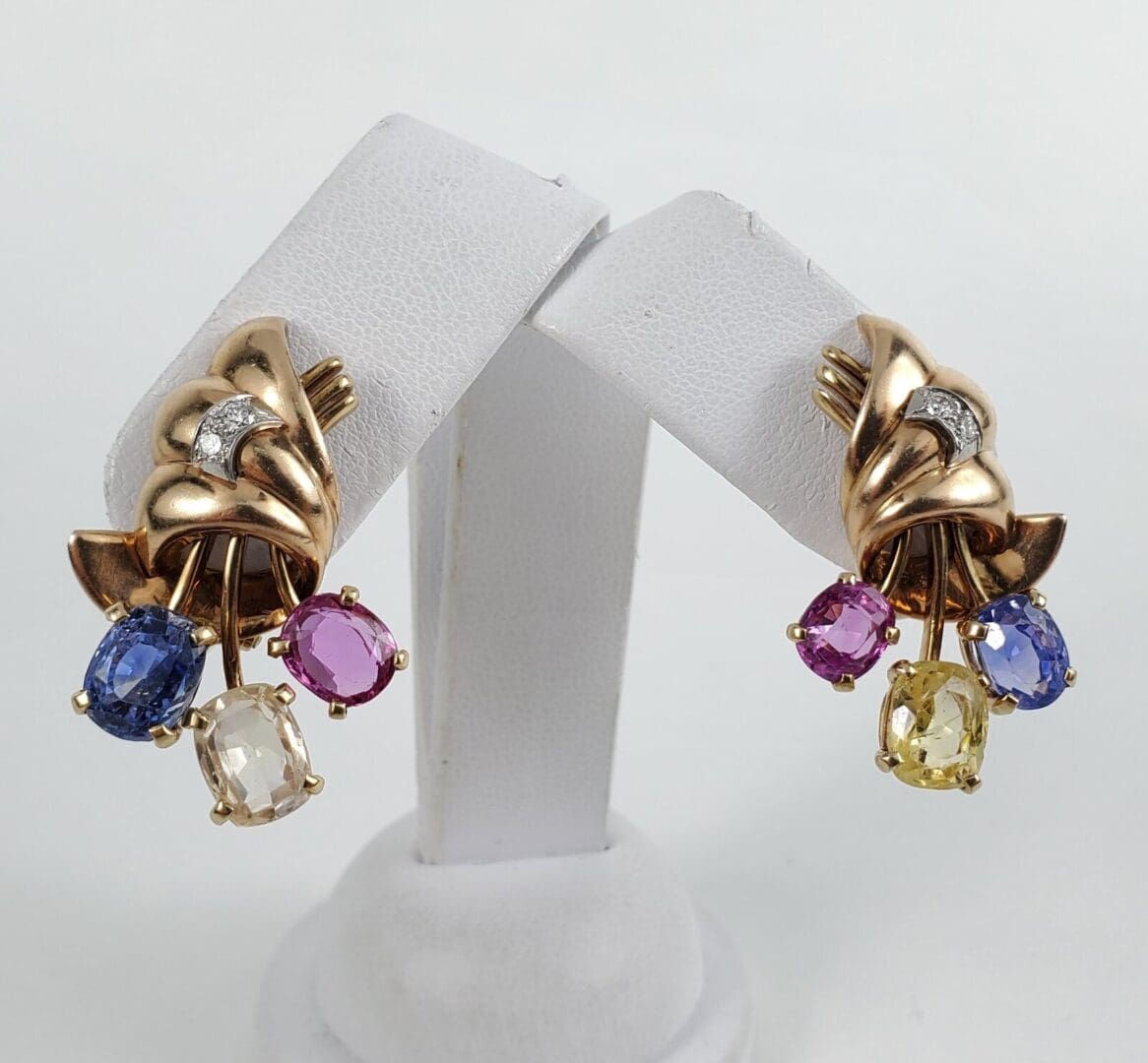 Gold earrings with colorful gemstone dangles.