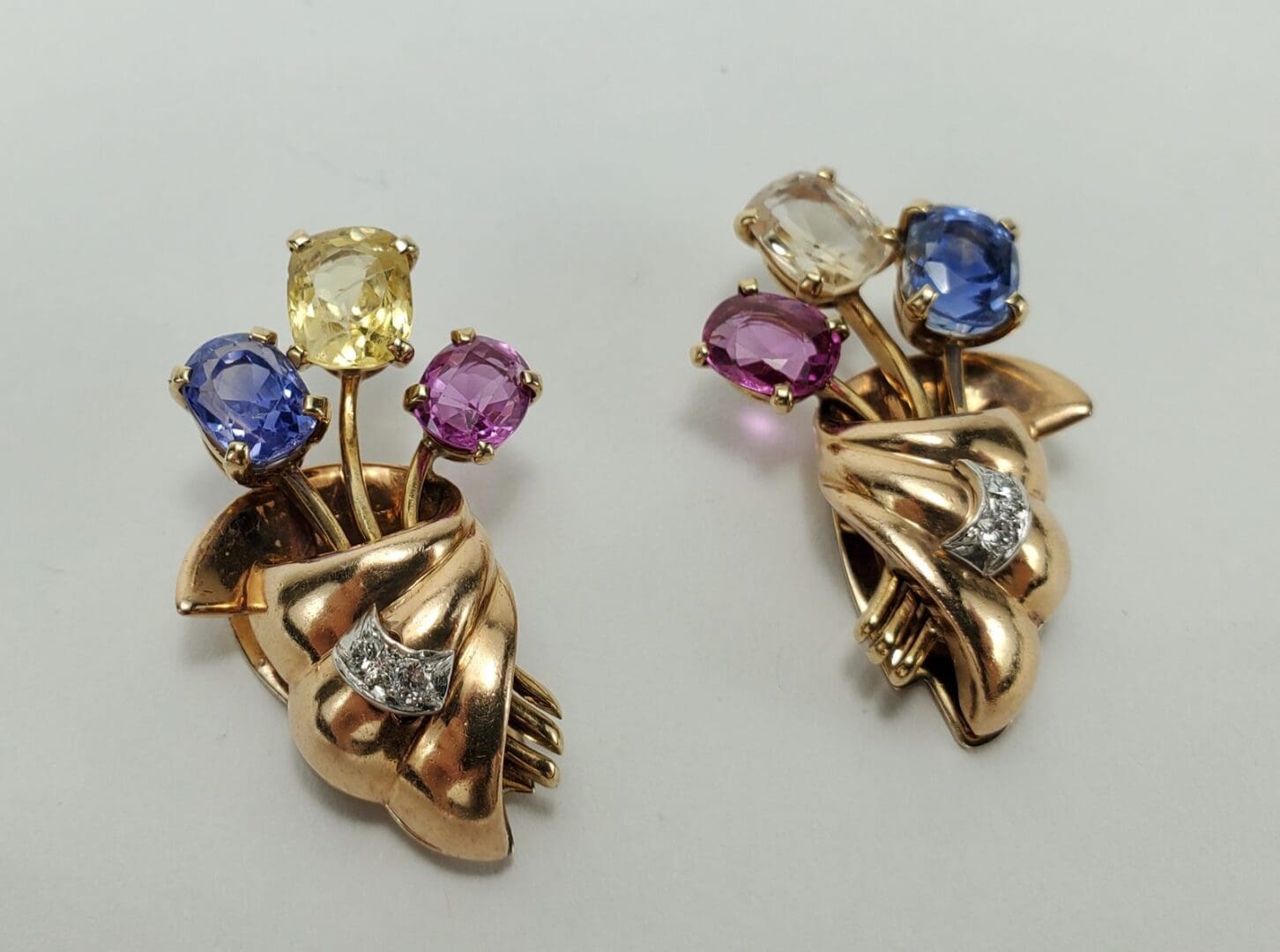 Gold brooches with colorful gemstone accents.