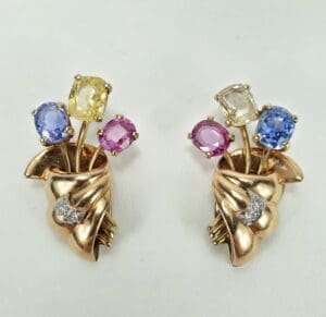 Gold earrings with colorful gemstone flowers.