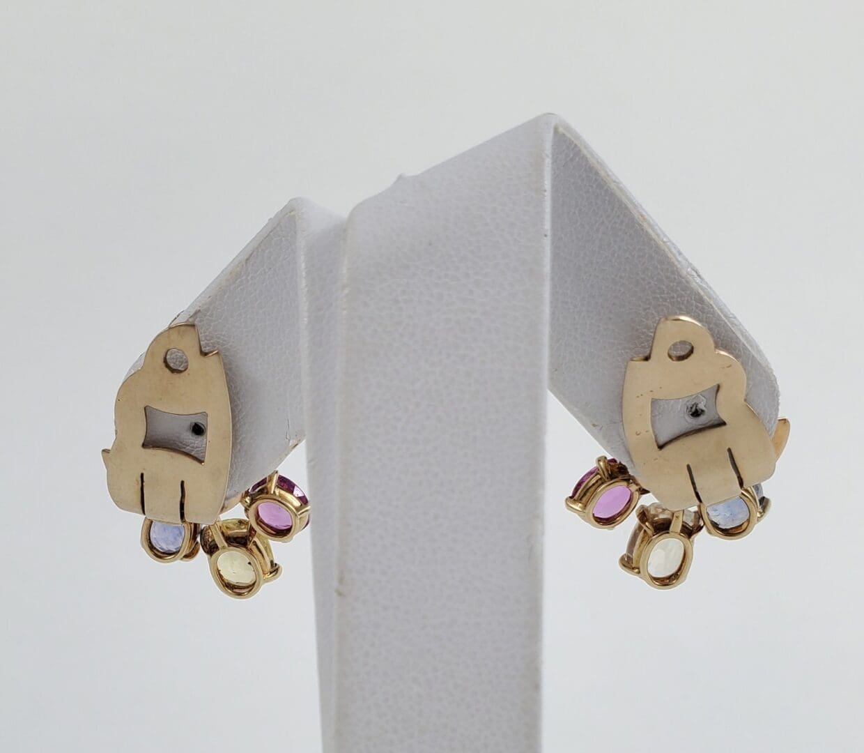 Gold earrings with colorful gem accents.