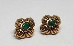 Gold earrings with green gemstones.