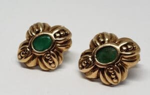 Gold earrings with green stone centers.