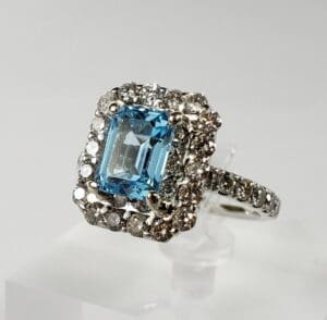 Silver ring with blue gemstone and diamonds.