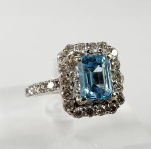 Silver ring with blue gemstone and diamonds.