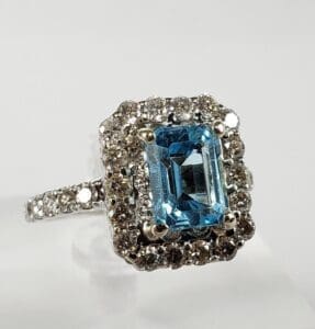Silver ring with blue gemstone and diamonds.