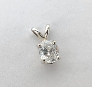 Silver pendant with oval-shaped clear gemstone.