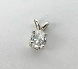 Oval diamond pendant on white background.