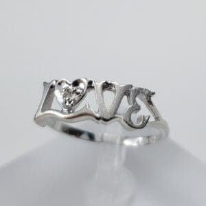 Silver ring with "love" and heart design.