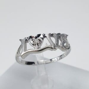 Silver ring with heart and "LOVE" design.