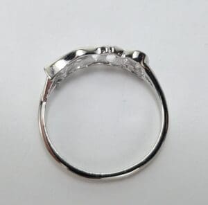 Silver ring with textured design, white background.