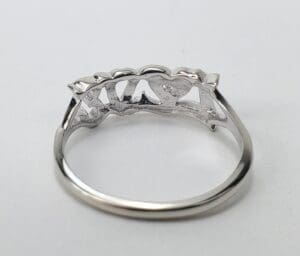 Silver ring with heart-shaped design underneath.