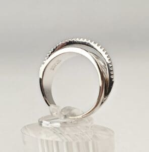 Silver ring with textured edge on display.