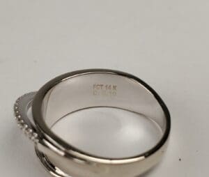 Silver ring with engraved specifications inside.