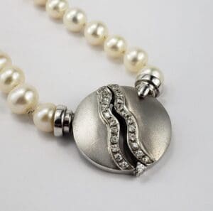 Pearl necklace with silver and diamond clasp.