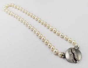 Pearl necklace with decorative round clasp.