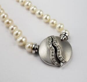 Pearl necklace with silver and diamond clasp.