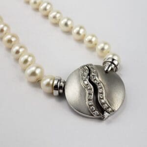Pearl necklace with silver and diamond clasp.