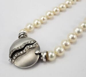 Pearl necklace with silver and diamond clasp.
