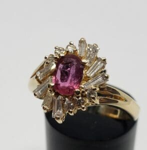 Gold ring with pink gemstone and diamonds.