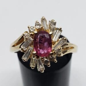 Gold ring with pink gemstone and diamonds.