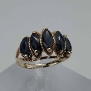 Gold ring with black marquise gemstones.