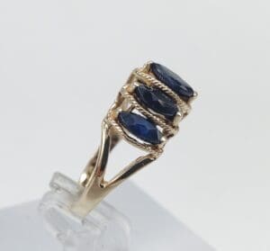 Gold ring with three blue gemstones.