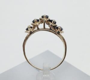 Gold ring with black gemstone accents.