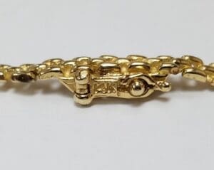 Gold bracelet clasp with "14K" marking.
