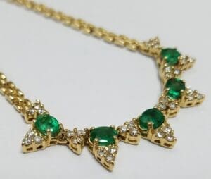 Gold necklace with emerald and diamond accents.