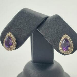 Purple teardrop earrings with diamond accents.