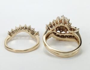 Gold rings with intricate prong settings displayed.