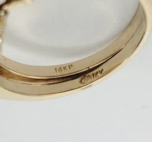 Gold ring with engraved markings inside band.