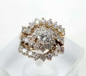 Gold ring with multiple diamond clusters.