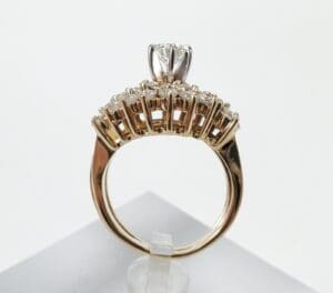 Gold ring with diamond on display stand.