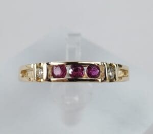 Gold ring with purple and clear stones.