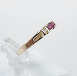 Gold ring with red and clear stones.