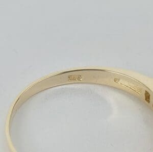 Gold ring with engraved hallmarks, close-up.