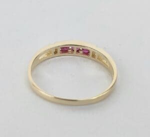 Gold ring with small pink stones.