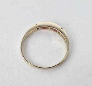 Gold ring with pink inlay, back view.