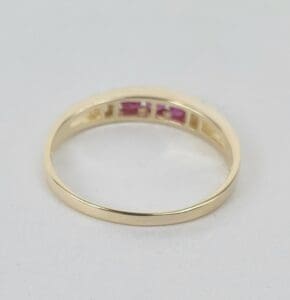 Gold ring with small pink stones.
