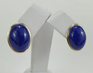 Blue oval earrings with gold trim.