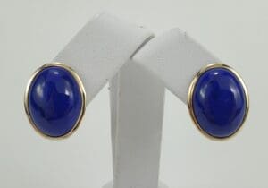 Gold-framed blue stone earrings on display.
