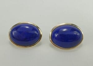 Gold-trimmed blue oval cufflinks on display.