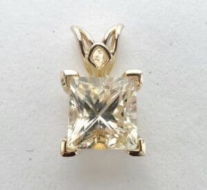 Square-cut diamond pendant with gold setting.